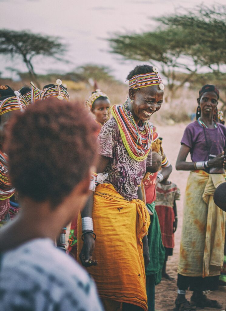 A woman smiled and dancing in tribe A tribe elder performing a cultural dance with others